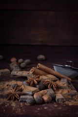 Chocolate, Spices, Spoon with Cocoa, Metal Strainer, Hazelnut on Dark Wooden Background. Copy space