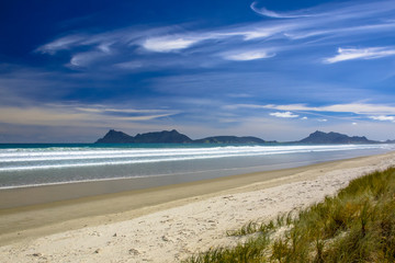 Fototapeta na wymiar White Sand Beach With Blue Sky at Waipu in New Zealand