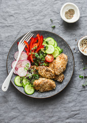 Sesame breading teriyaki baked chicken breast and fresh vegetables. Baked chicken and tomatoes, cucumbers, peppers, radishes, micro greens salad, top view. Flat lay