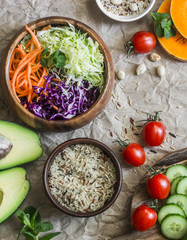 Healthy vegetarian food set background. Cabbage salad, avocado, tomatoes, cucumbers, pumpkin, wild rice on a paper background, top view. Flat lay