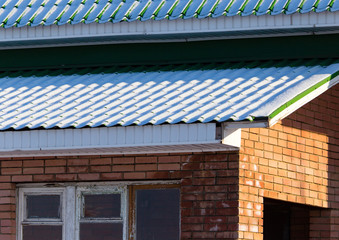 Snow on the roof of the house in winter
