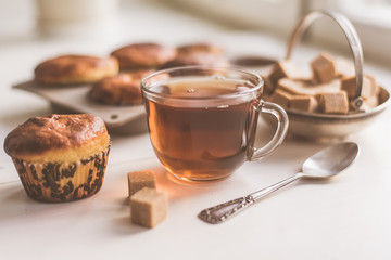 A glass of tea and freshly baked muffins on the table - natural light