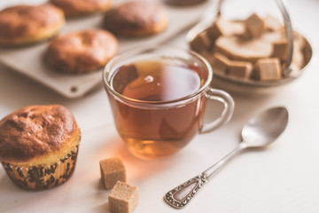 A glass of tea and freshly baked muffins on the table - natural light