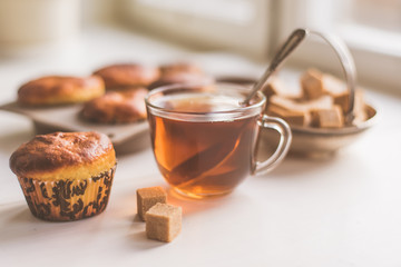 A glass of tea and freshly baked muffins on the table - natural light