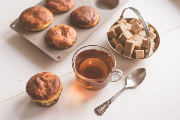 A glass of tea and freshly baked muffins on the table - natural light