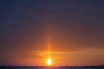 Sunrise over the meadow in the winter in a strong frost.