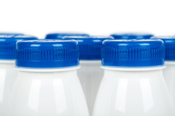 Group of white plastic bottles with drink yogurt or milk. Isolated on white background. Container merchandise template, macro image