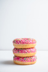 Donut with sprinkles on the rustic wooden background. Selective focus.
