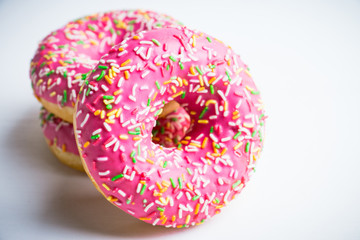 Donut with sprinkles on the rustic wooden background. Selective focus.