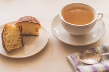 cup of green tea, fresh cake and a napkin on a light table - rustic breakfast