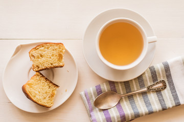 cup of green tea, fresh cake and a napkin on a light table - rustic breakfast