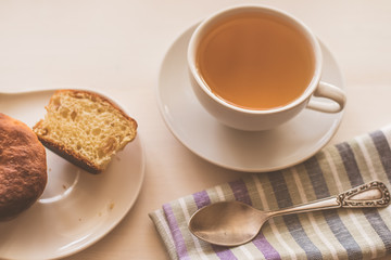 cup of green tea, fresh cake and a napkin on a light table - rustic breakfast