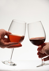 Two red wine glasses in hands