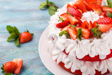 Strawberry and cream sponge cake. Homemade summer dessert on blue wooden table