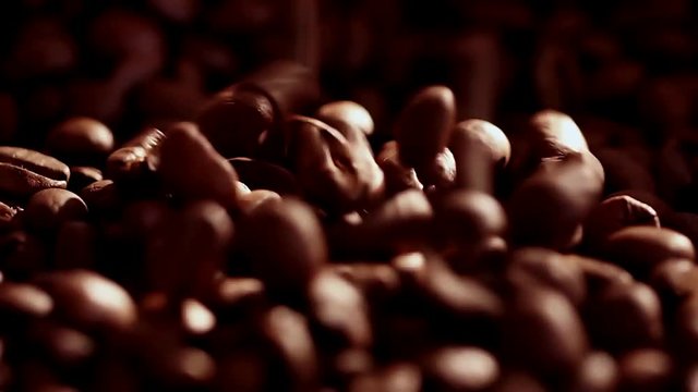Coffee close up. Coffee beans. Coffee beans. Sunshine on coffee seeds. Slow mothion. The ready fried coffee beans.. Dark Coffee Grains.
