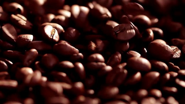 Coffee close up. Coffee beans. Sunshine on coffee seeds. Slow mothion. Seeds of coffee fall. Dark Coffee Grains.