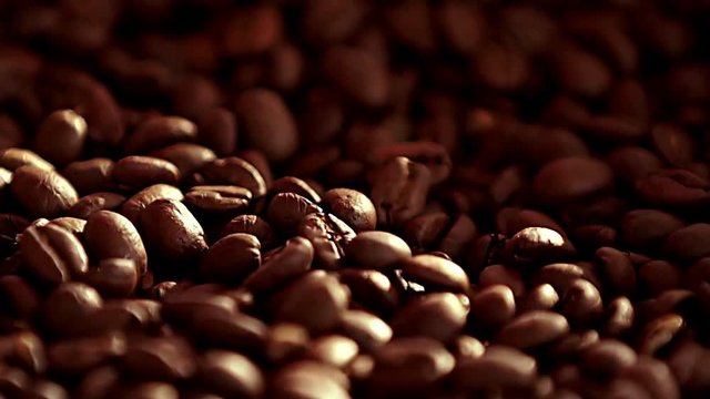 Coffee close up. Coffee. Sunshine on coffee seeds.The ready fried coffee beans. Slow mothion .Seeds of coffee fall. Dark Coffee Grains.