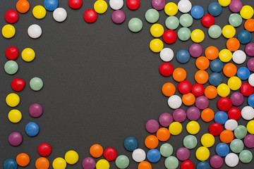 Multicolored candy and lollipops on a gray background.