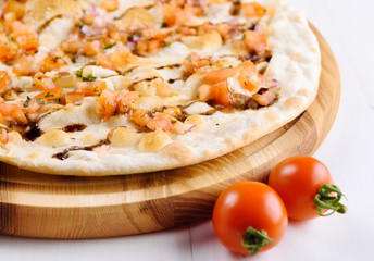 Fresh traditional italian focaccia bread with tomatoes, onions, rosemary and olive oil on wooden board, selective focus. Healthy homemade flatbread focaccia, copy space