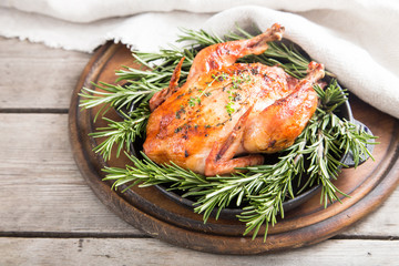 Fried whole chicken with herbs over natural wood background. whole roasted chicken
