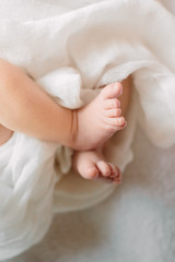 Cute newborn girl sleeping on furry cloth wearing white headband