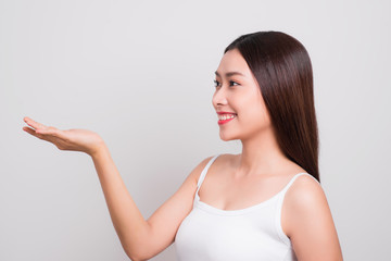 Fototapeta premium Portrait of a beautiful young woman with clean skin gesture hand.