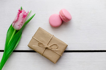 Tulip, gift boxes and macaroons wooden white background