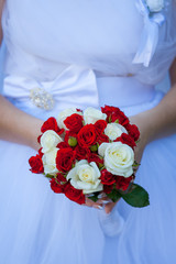 Wedding flowers. Beautiful fresh little new round bouquet of different colors. The bride in the background. Beautiful photo for web sites and postcards.