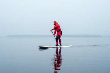 athletic man stand up paddle board
