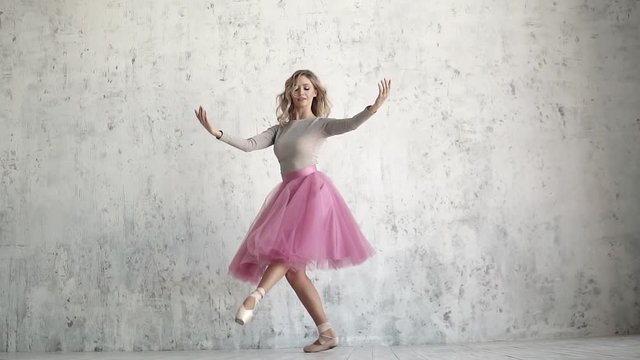 young ballerina is dancing a classical ballet. ballet dancer in a pink tutu and golden pointes