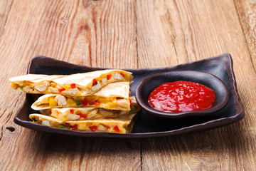 Quesadilla with chicken, served with guacamole or salsa sauce.