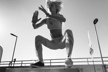 Fit young woman doing box jumping.