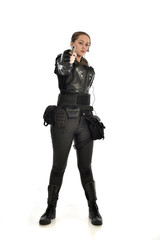 full length portrait of female  soldier wearing black  tactical armour, holding a gun, isolated on white studio background.