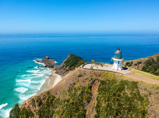 Fototapeta na wymiar Stunning wide angle aerial drone view of Cape Reinga Lighthouse at Cape Reinga, the northernmost point of the North Island of New Zealand. The lighthouse is a famous tourist attraction.