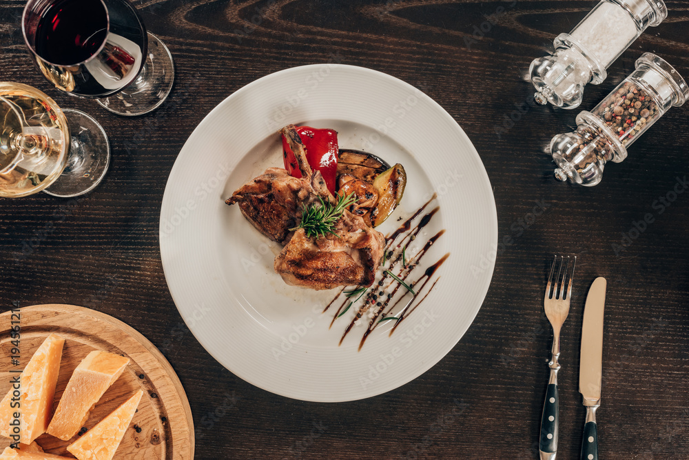 Wall mural top view of grilled chicken with vegetables on plate on table