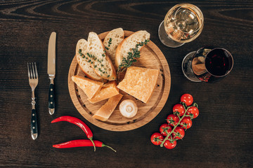 top view of parmesan cheese with baguette slices and cherry tomatoes on table