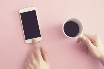 Using mobile phone holding coffee cup