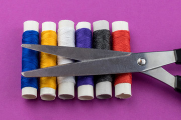 A bunch of colorful thread coils and scissors