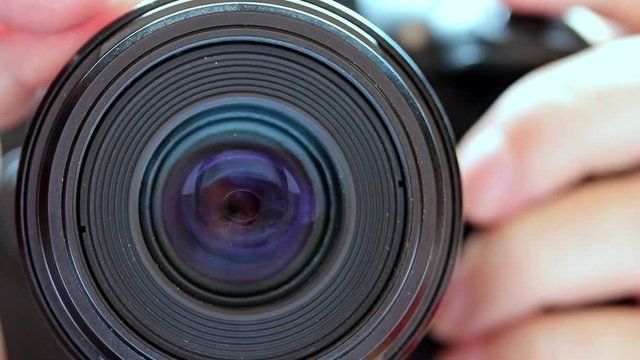 Detail of fast focus of the camera lens, front view. Gradually zooming the lens, close-up.