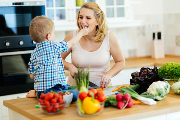 Pregnant woman preparing meal with son
