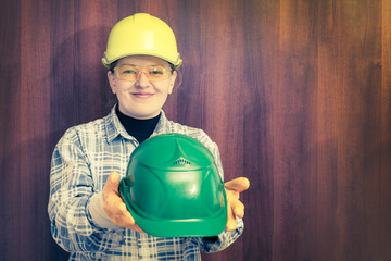 A woman builder offers a protective helmet