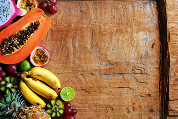 Top view of mixed exotic fruits on wooden table with copy space.