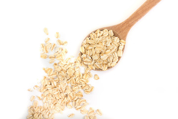 Pile of organic oat flakes and full wooden spoon in top view. 