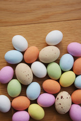 Multicolored chocolate Easter eggs on wooden table. Easter background
