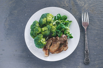 Broccoli, lettuce corn and meat in a plate
