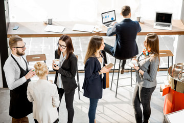 Business people having a conversation during the coffee break standing with waiter in the cafe