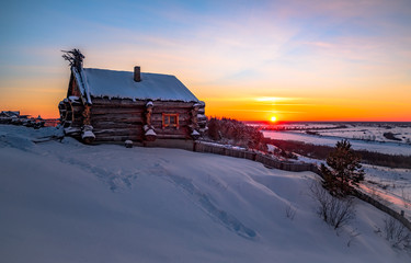 forest cabin and tree in winter. wooden hut in the snow. log house on the evening sky. sunset over the snowy valley