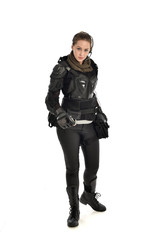 Fototapeta premium full length portrait of female soldier wearing black tactical armour, holding a remote knife, isolated on white studio background.