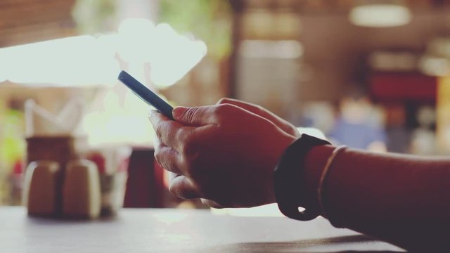 Female hands surfing web on smartphone wearing clock with pedometer sitting with blurred bokeh. slow motion. 3840x2160