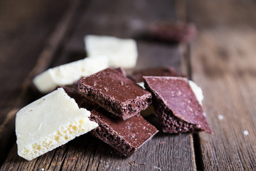 Pieces of white and dark porous chocolate